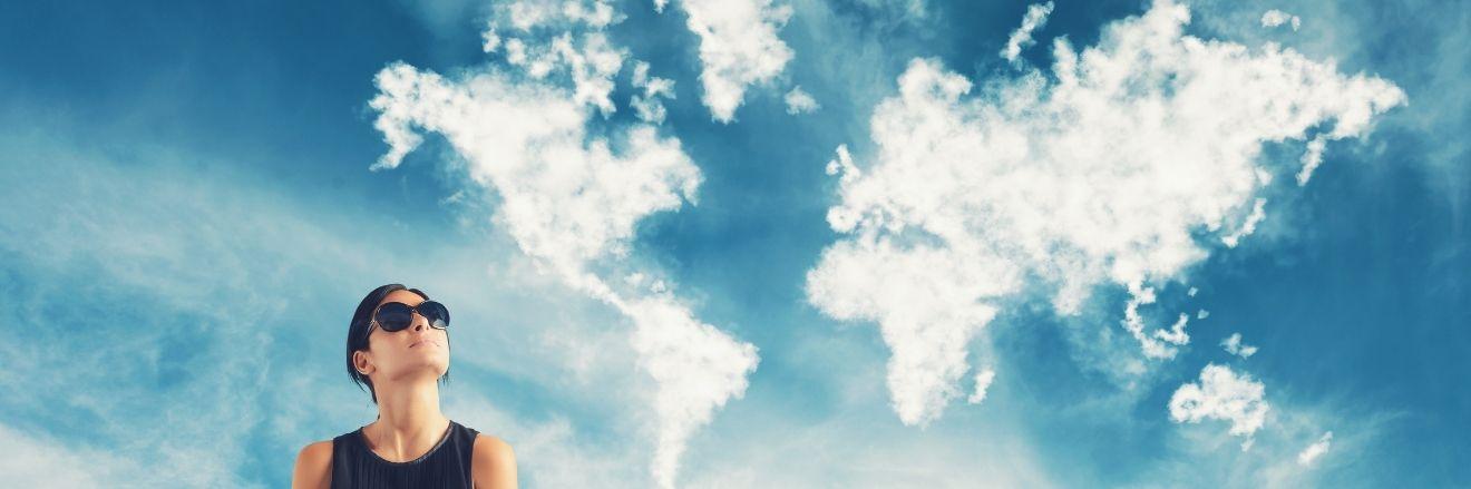 ragazza che guarda delle nuvole del cielo, che hanno la forma dei continenti della terra